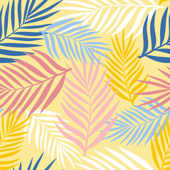 Fototapeta na wymiar Palm leaves of different colors on a pale yellow background. Seamless pattern for any use.