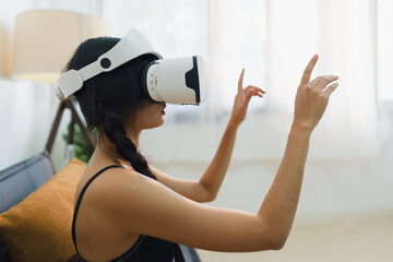 Young Asian woman wearing VR eyeglasses and gesturing on the air, Isolation girl playing metaverse...