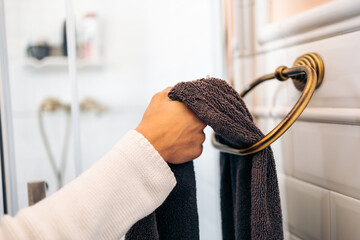 Hands of a woman grabbing with a towel to dry her hands