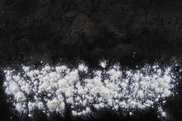 Natural background and abstraction. The texture of flour for cooking dough on a black background.