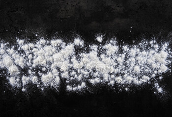Natural background and abstraction. The texture of flour for cooking dough on a black background.