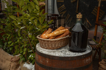 Large Vintage Wine Bottles in wicker basket on a barrel