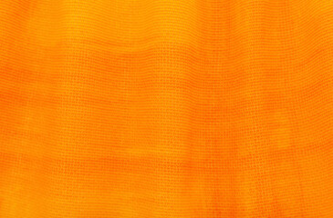 Fototapeta premium A piece of orange fabric with abstract lines and waves. Yellow textile. Curtain. Tulle or satin