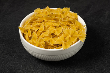 Raw Cavatappi Cellentani pasta in a plate isolated on dark background top view