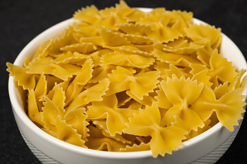 Raw Cavatappi Cellentani pasta in a plate isolated on dark background top view