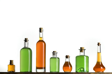 Several glass transparent bottles with cork stopper on a store shelf. Vintage glass bottles with colorful liquids on a white background. - 482231037