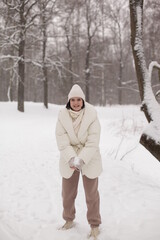 Two girls playing snowballs in the snow in the winter in a warm winter clothes