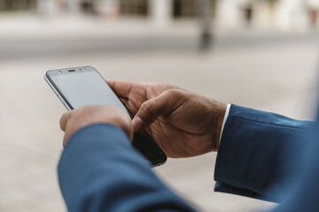 close-up view of unrecognizable dark skinned businessman using smartphone