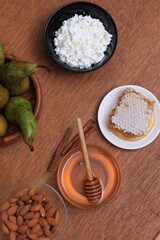 Honey, nuts, fruits on a wooden table. Still life of natural products on a black background.