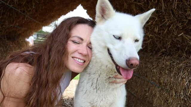 Beautiful red-haired woman hugging the husky. High quality photo