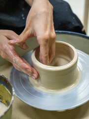 A close-up of a craftsman making an object out of clay on a potter's wheel. Handmade, hobby, hobby