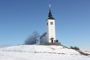 Fototapeta na wymiar St. Cross church above Skofja Loka - Slovenia. Easy hike, accessible even by dirt road.