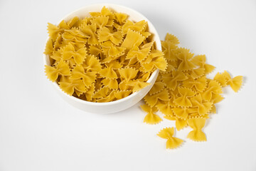 Close up of several types of dry pasta in a plate on white background