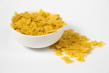 Close up of several types of dry pasta in a plate on white background