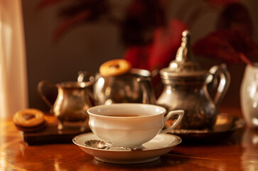 Obraz na płótnie Canvas White porcelain cup and tea set. Still life in vintage style, selective focus, close-up
