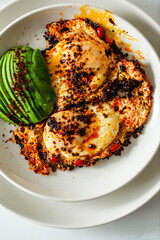 Fried Chili Spicy Egg Breakfast with Fresh Avocado on White Kitchen Background