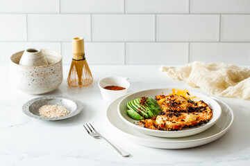 Fried Chili Spicy Egg Breakfast with Fresh Avocado on White Kitchen Background
