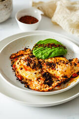 Fried Chili Spicy Egg Breakfast with Fresh Avocado on White Kitchen Background