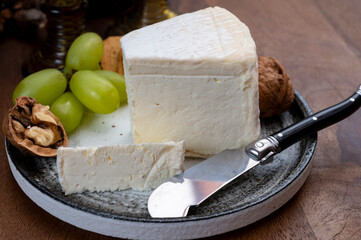 Delice de Bourgogne French cow's milk cheese from Burgundy region of France served with grapes, wine and walnuts