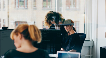 Smiling businesswomen working at a computer