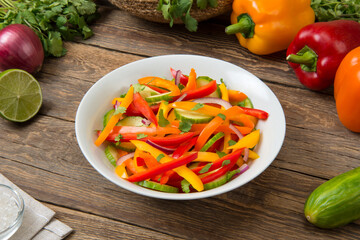 Salad of bell pepper, cucumber on an old rural table with ingredients. Selected focus.