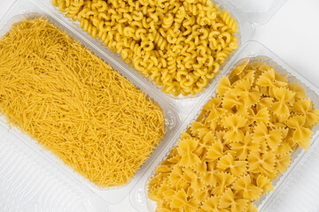 Close up of several types of dry pasta in a plate on white background