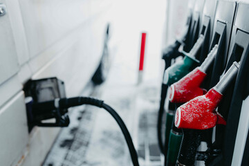 Refueling a car with fuel, filling station in the snow.
