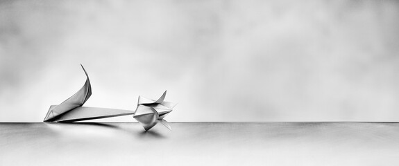 Origami Blume aus silbernem Papier auf grauem Hintergrund