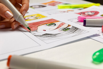 An artist draws a storyboard of an anime comics book. Manga style. The designer animator draws with...