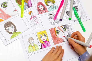 An artist draws a storyboard of an anime comics book. Manga style. The designer animator draws with...