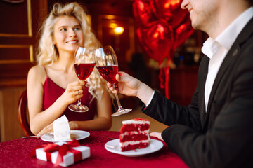 Valentine's Day concept. Exchange of gifts. Beautiful young couple celebrating Valentine's Day  in the restaurant. Hug, kiss and enjoy spending time together.