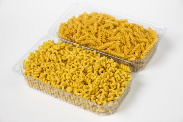 Close up of several types of dry pasta in a plate on white background