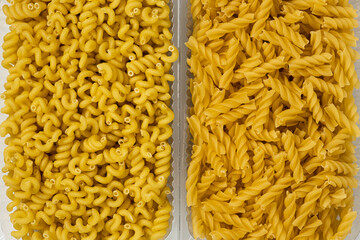 Close up of several types of dry pasta in a plate on white background