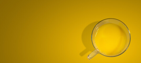 Banner with a glass filled with orange juice just made from fresh fruits, at gradient orange background with copy space. Concept of healthy food, vitamins and healthy life.