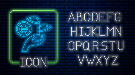 Glowing neon Leaf in hand of environmental protection icon isolated on brick wall background. Seed and seedling. Planting sapling. Ecology concept. Neon light alphabet. Vector