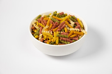 Pasta trottole tricolore wheat in a plate isolated on white background