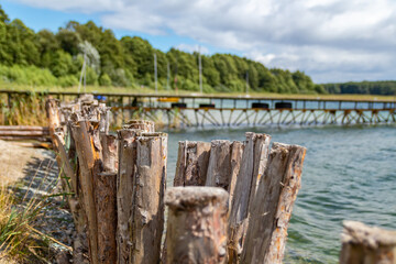 Beautiful view over Powidzkie lake during summer in sunny windy day. Wood palisade near water.