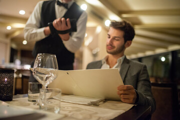 Man looking at a menu in the restaurant