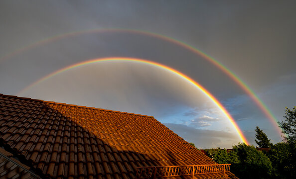 Wide angle view of a double rainbow with colorful interference pattern on the inner edge.
