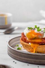 Toasted bread with poached egg, ham and onion for cooking benedict egg on white background. English brunch
