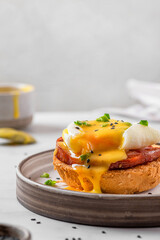 Egg benedict. Poached egg, ham, hollandaise sauce, onion on slice toast for tasty breakfast. vertical orientation.