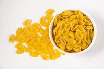 Close up of several types of dry pasta in a plate on white background