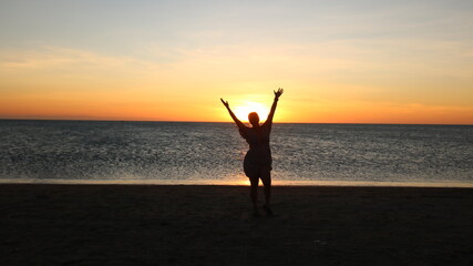 Fototapeta premium person on the beach at sunset