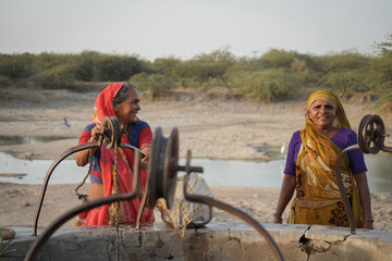 Old indian women laughing near well in indian village