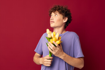 kinky guy holding a yellow bouquet of flowers purple t-shirts red background unaltered