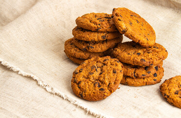 Homemade chocolate chip cookies scattered on gray cloth