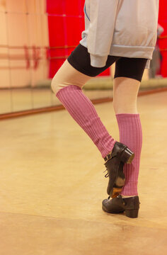 Irish dance lessons, teenage girl in special hard shoes and purple leggings practices exercises in front of a mirror, lifestyle