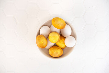 Yellow and white Easter eggs in a bowl. Natural coloring Easter eggs with turmeric powder in yellow color.