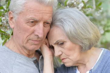 Sad Elderly couple together in park