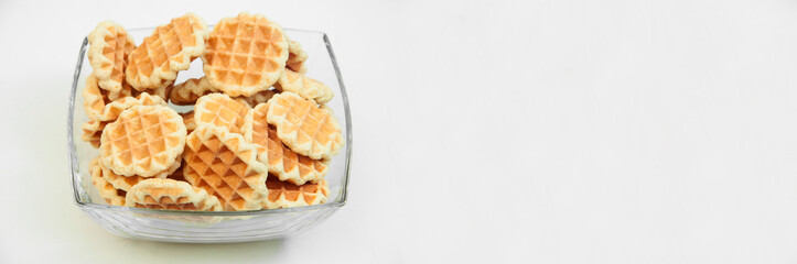 Belgian waffles in a glass bowl. holiday cookies on a white background. fresh baking concept. sweet desserts on a light texture